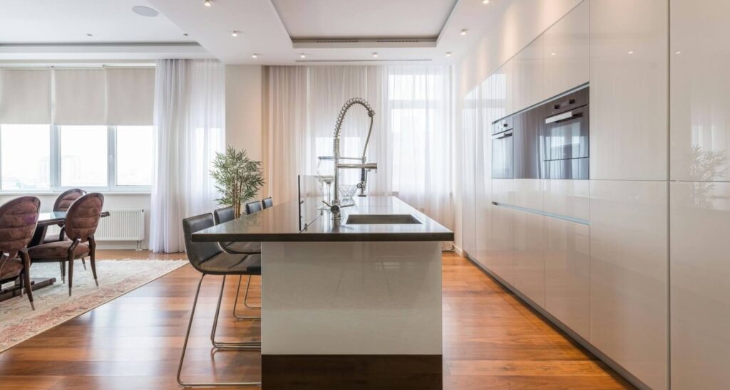 Elegant modern kitchen island with seating and stainless steel appliances in a Sarasota home, enhancing functionality and style.