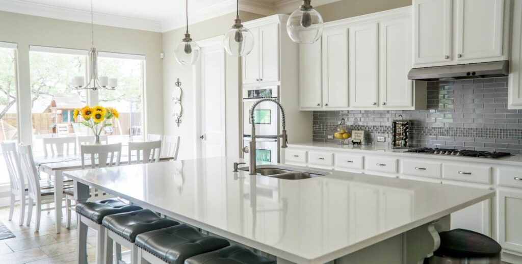 Modern Sarasota kitchen with an open concept design, uniting kitchen, dining, and living areas in a bright, social space filled with natural light.